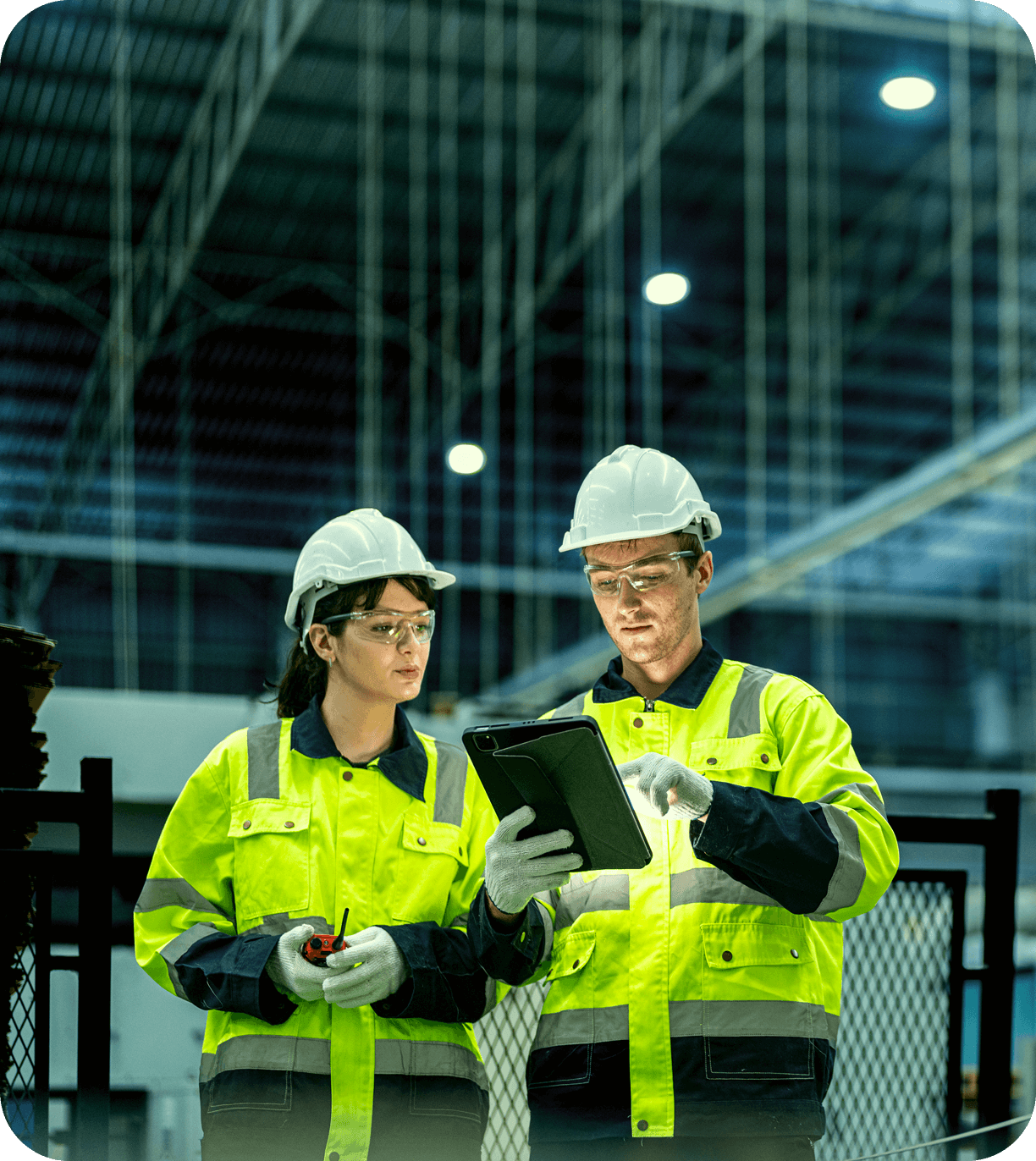 Workers in safety gear reviewing tablet information.
